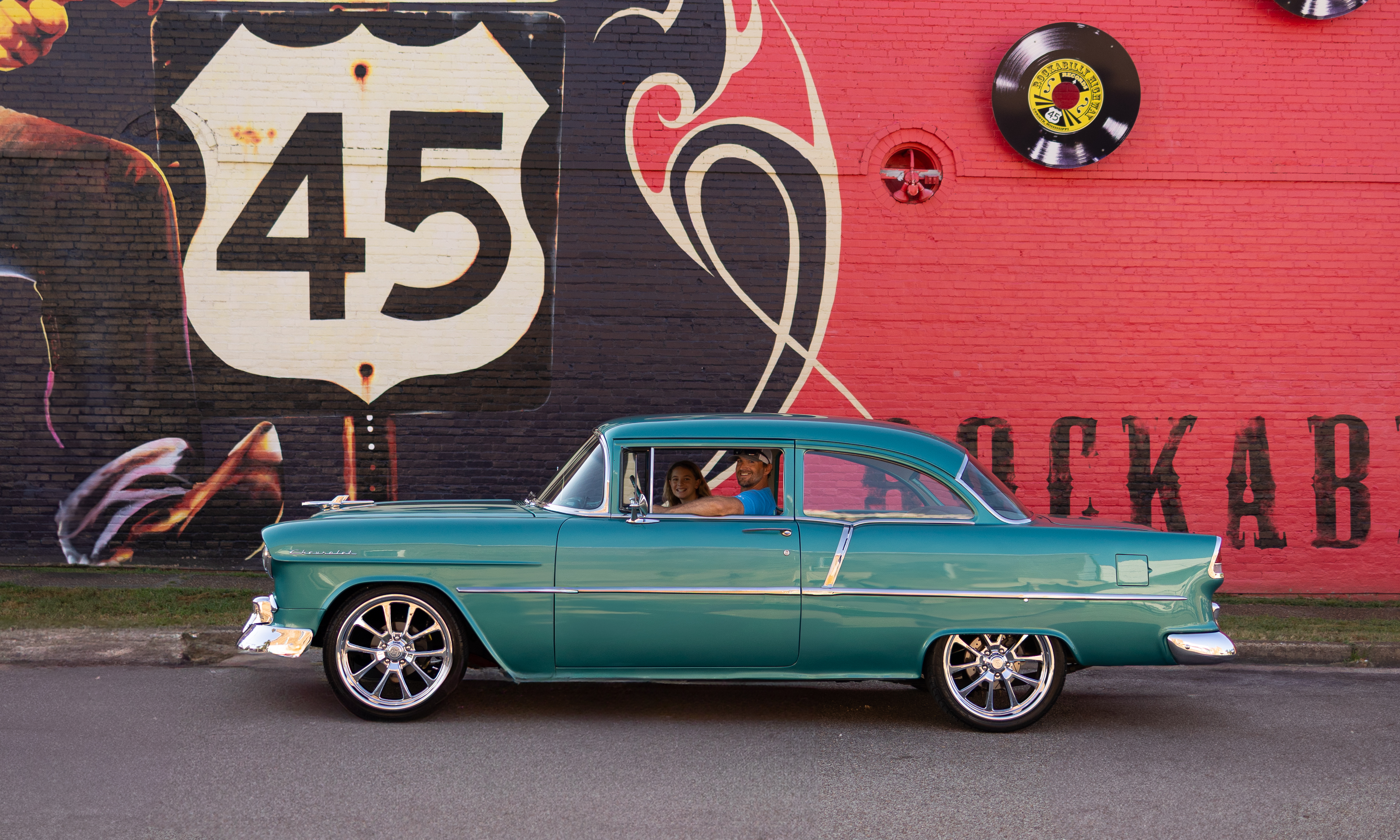 Classic car cruising past the Route 45 Rockabilly Highway mural in Selmer, Tennessee
